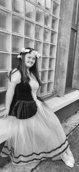 Young girl in theatrical dress sitting on a ledge