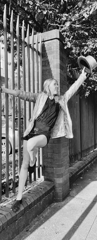Jazz dancer hanging off a fence